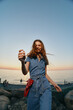 © SHOTPRIME STUDIO - lifestyle woman in modern boho-western denim street style enjoying sunset by the sea with film color tones and relaxed, joyful expression