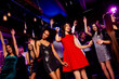 © deagreez - Energetic party night on the dance floor with stylish dancers in bright dresses and neon club lights