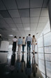 © qunica.com - A group of coworkers walks through a bright, modern office corridor. Their casual business attire and purposeful pace convey collaboration, movement, and a dynamic workplace atmosphere.