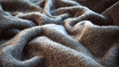 © Thiago - A close-up shot of a soft, gray woolen fabric. The texture of the cloth is evident in the folds and waves