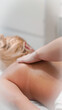 © Наталья Добровольска - Gentle massage hands working on blonde client creating calm salon atmosphere.