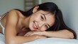 © natakot - Smiling young woman with long hair resting on a soft surface