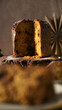 © homydesign - Vertical Close-up of Sliced Panettone with Powdered Sugar and Dramatic Lighting