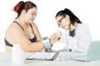 © Creativa Images - Female doctor checking the blood pressure of an obese patient with a digital monitor