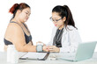 © Creativa Images - Asian doctor taking the blood pressure of a female obese patient in a clinic