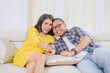 © Creativa Images - Happy Affectionate Couple Watching Television Together on Sofa with Remote Control