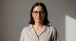 © bayu - Confident professional woman wearing glasses with a neutral background