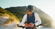© peopleimages.com - Fitness, cycling and man with phone in nature for networking, chatting or connectivity with training. Sports, cyclist and athlete with cellphone for texting, communication or contact on mobile app.