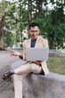© crizzystudio - Asian businessman using laptop outdoors during video call