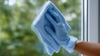 © Gulnaz - A person is cleaning a window with a blue cloth