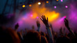 © kobkeroku - Concert crowd with raised hands enjoying vibrant stage lights in purple and orange hues, capturing the energetic atmosphere of a live music event