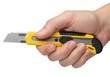 © JPEG & PNG House  - Hand firmly holding a sharp yellow utility knife, precision cutting tool ready for crafting projects or industrial tasks with durable blade, versatile tool