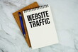 © may1985 - Website Traffic text written on notepad with pen on marble background