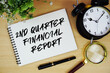 © may1985 - 2nd Quarter Financial Report text written on notepad with alarm clock and magnifying glass flat lay on wooden background