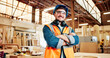 © P2000/peopleimages.com - Carpentry, crossed arms and portrait of man in factory for furniture repair, restoration and woodworking. Carpenter, safety gear and happy person in workshop for wood, lumber and timber production