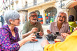 © unai - Group of senior friends enjoying coffee time laughing outdoors