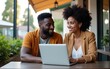 © Owen - Coworking and freelance concept.Mixed race, middle age black skin man and woman working together on laptop computer while sitting on cafe terrace. High quality