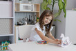© Yuliia Kostiuchenko - The kid girl is playing board educational game at the table in the children's room. The concept of child development. The concept of leisure for children