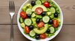 © Ada - Fresh Vegetable Salad in Bowl Top View. fresh, colorful vegetable salad in a white ceramic bowl. Ingredients include lettuce, cherry tomatoes, cucumber, avocado, and olives