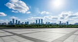 Modern city skyline, office buildings, green urban park, and spacious empty outdoor plaza on a sunny day