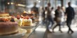 © musthofa - A bakery display with desserts in focus, blurred people outside window