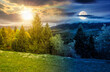 © Pellinni - spruce forest on a hill side meadow in high mountains on spring equinox. day and night time change concept. countryside landscape for sustainability with sun and moon. duality and transition template