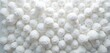 © miss irine - White small balls of foamed polystyrene material create abstract textured background. Many textured spheres fill frame, showing light clean pattern. Surface looks like industrial styrene packaging