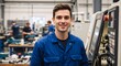 © Vasiliy - Smiling factory worker in blue uniform standing next to CNC machine. Portrait of a young industrial engineer in a modern manufacturing plant
