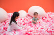 © leungchopan - Mother and baby playing together in colorful ball pit