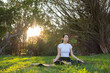 © leungchopan - Female practicing mindfulness meditation while sitting on green grass