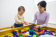 © leungchopan - Baby playing with magnet tiles in playhouse with mother