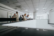 © qunica.com - A bright, contemporary office lobby shows a diverse group of people collaborating at a reception desk and workstation. Laptops glow as teammates discuss projects in a calm, professional environment.
