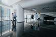© qunica.com - A group of people walks through a spacious, contemporary office lobby, reflecting on the polished floor and bright windows, conveying movement, collaboration, and urban work life.