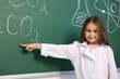 © New Africa - Smiling little girl in laboratory coat pointing at something at green chalkboard with formulas. Child and science