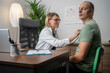 © Nenad - Female middle-aged doctor using stethoscope to examine patient.