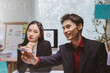 © amnaj - Asian business professionals discussing strategy and pointing at a glass board, showing teamwork and effective communication