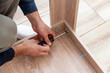 © dramapalma - Man handyman furniture assembler assemble table with hand screwdriver and screws