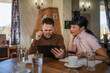 © Miljan Živković - Mature business colleagues discussing planning using digital tablet in cafe