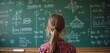 © Vadym - Girl with backpack studies math formulas on green chalkboard. Student learns complex equations in classroom. Studying hard for exam, science lesson, education concept.