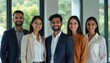 © Vadym - Five Indian professionals smile for a group photo in a modern office. Teamwork and collaboration evident in their confident attire and relaxed poses. They represent a diverse workforce.