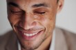 © Studicon - Close up of a man smiling with his eyes closed, showing his teeth