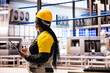 © DC Studio - Power plant engineer conducting equipment assessments, looking around the facility with tablet in hand. African American factory manager overseeing digital simulations of manufacturing processes.