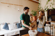 © Drobot Dean - A man and a woman stand at a table while laughing and looking at a potted plant he is holding