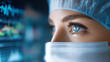 © Yuparet - Close up of female healthcare worker with blue eyes wearing surgical mask and cap, focused and determined, with medical monitor reflection in background