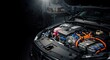 © Vyatcheslav - Modern car engine under open hood in garage. Hybrid electric vehicle motor detail with orange high voltage cables. Copy space for text