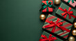 © Taslima - Overhead view of beautifully wrapped christmas gift boxes with red ribbons and gold baubles arranged on a dark green background with copy space on the left