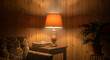 © ManuStockStudio - Vintage table lamp casts warm inviting glow on wooden wall in cozy retro home interior evening scene
