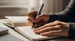 © Agus Through Lens - Close up of hands holding pen and writing plans or thoughts in open notebook on desk under sunlight