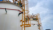 © supakitmod - Large chemical storage tank inside an industrial plant with a vertical ladder for access to the top,