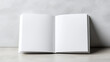 © siraphol - Open blank hardcover book on textured surface with soft cinematic light evoking calm
